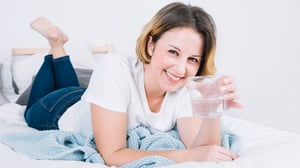 smiling-woman-with-water-lying-bed